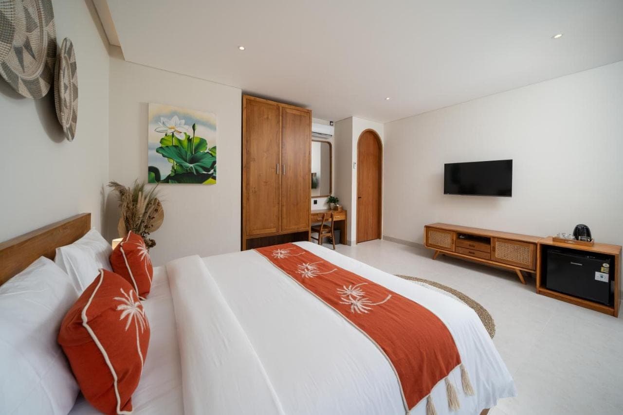 a bedroom with a bed and a flat screen tv at Uluwatu Bagus Homestay in Uluwatu
