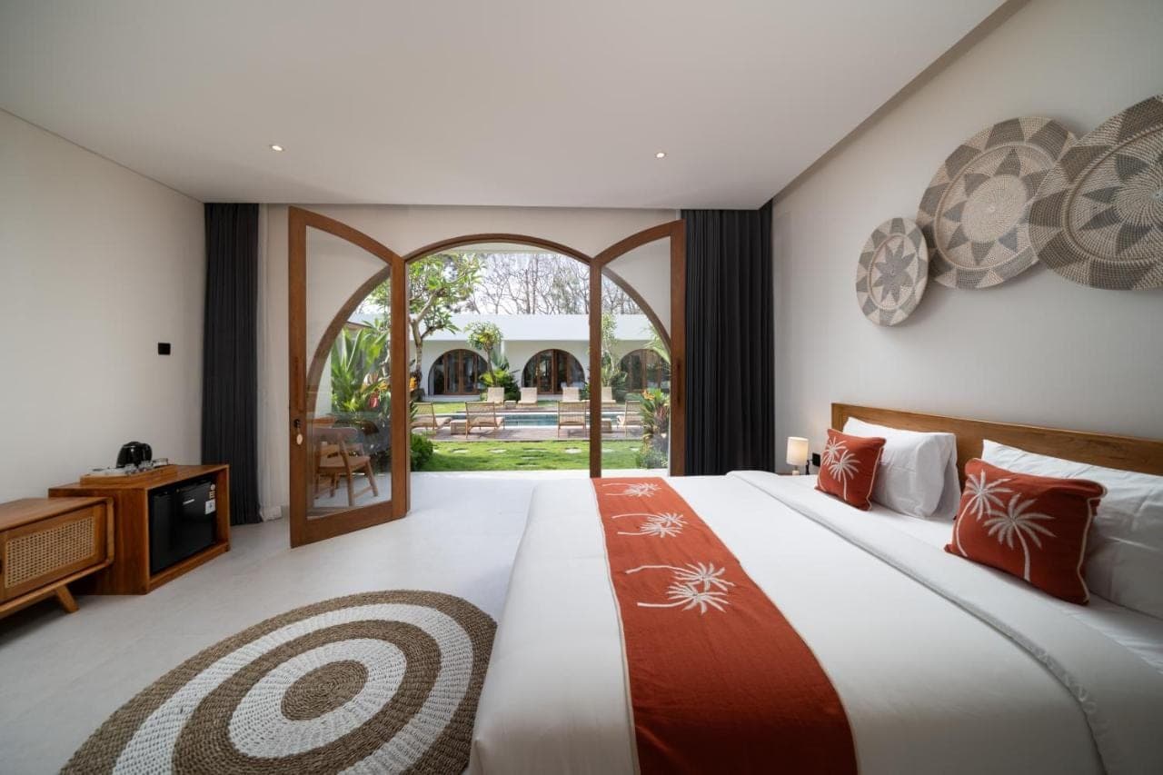 a bedroom with two beds and an open door at Uluwatu Bagus Homestay in Uluwatu
