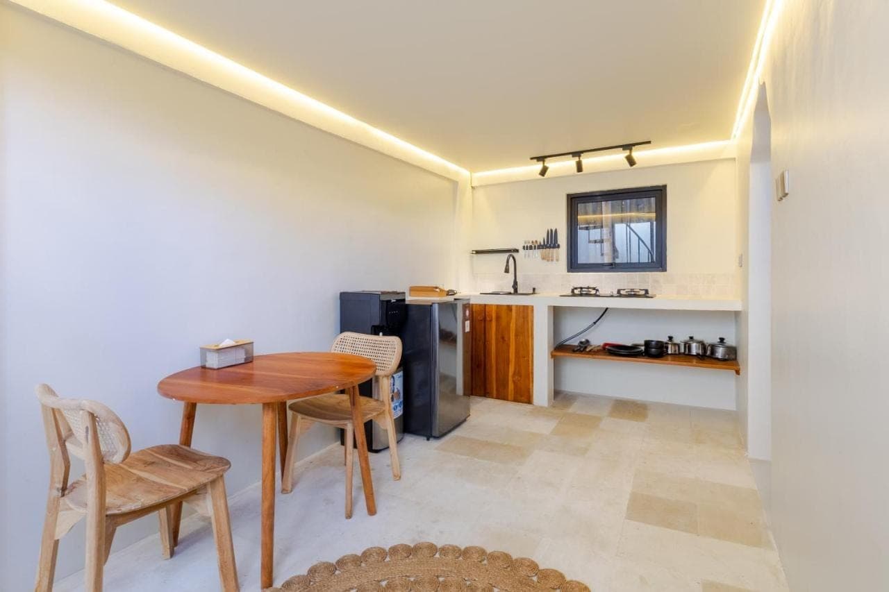 a kitchen and dining room with a table and chairs at Djati Retreat & Yoga Lounge by Pertama Stay in Nusa Dua