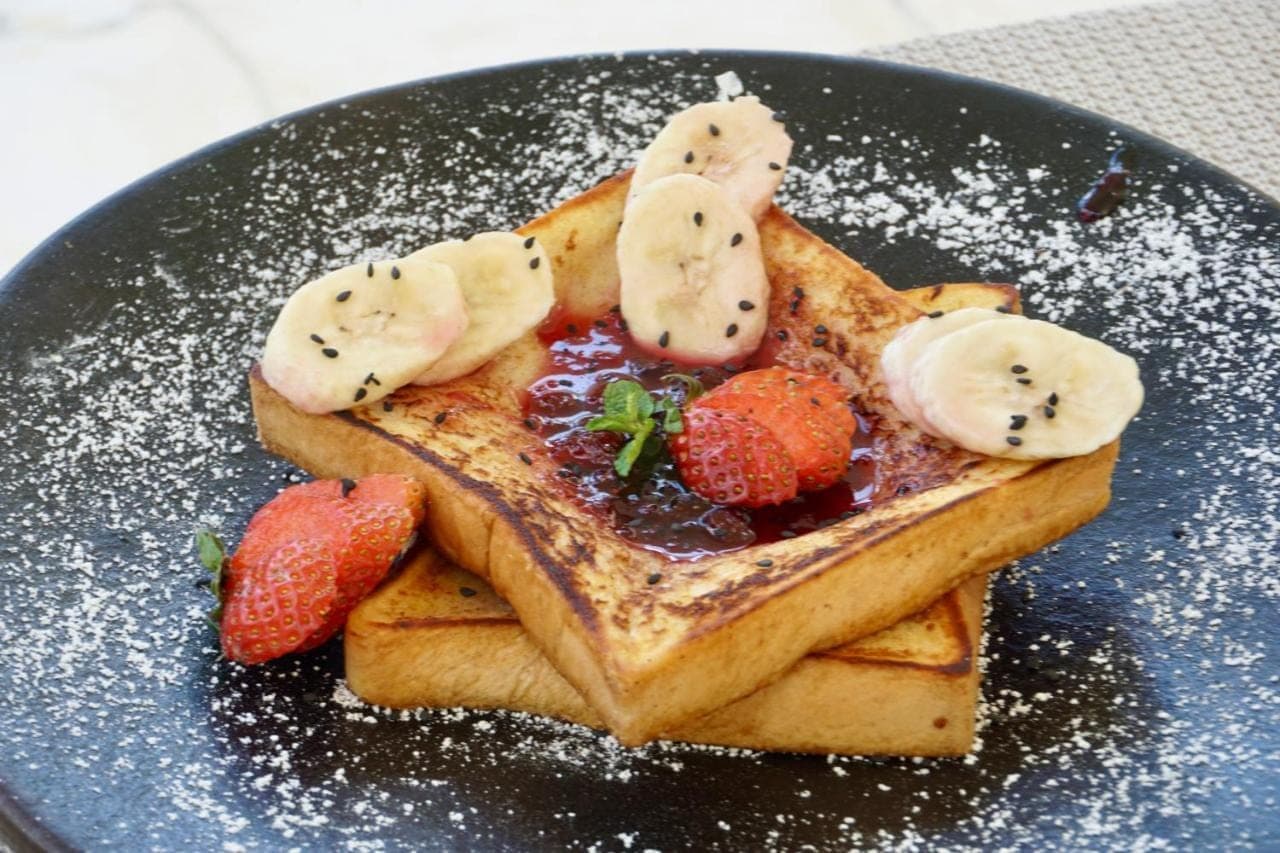 a plate of waffles with strawberries and bananas on it at Djati Retreat & Yoga Lounge by Pertama Stay in Nusa Dua