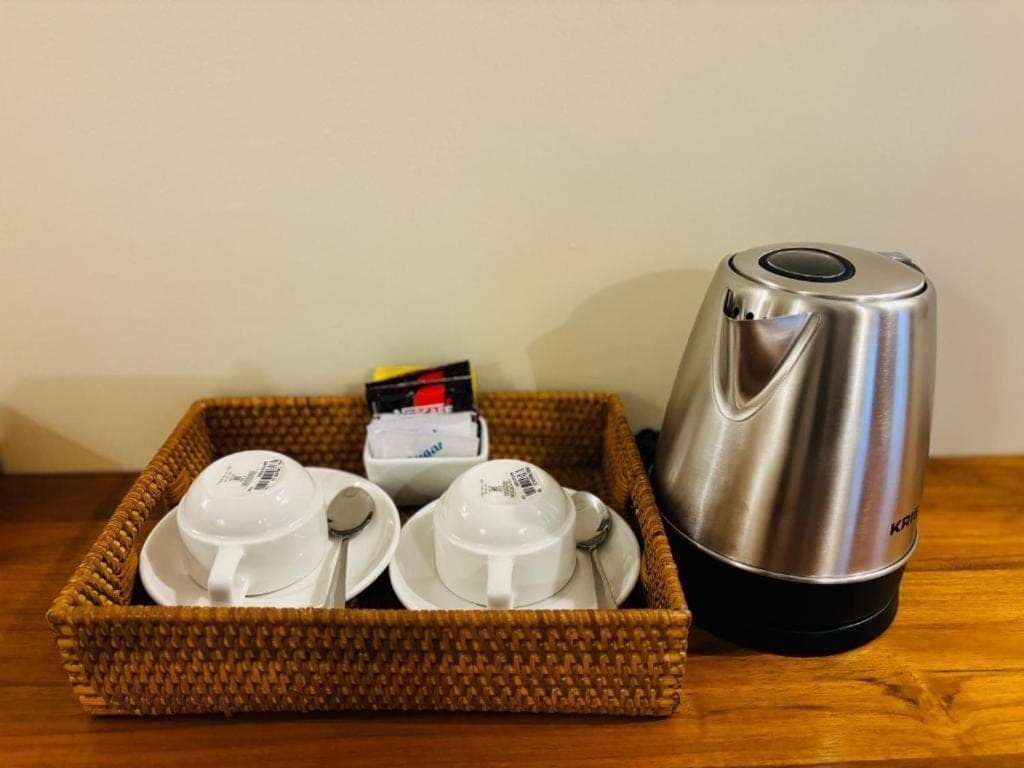 a basket with a tea kettle and tea cups on a table at Pondok Wisata Amerta Semaya Agung in Ubud