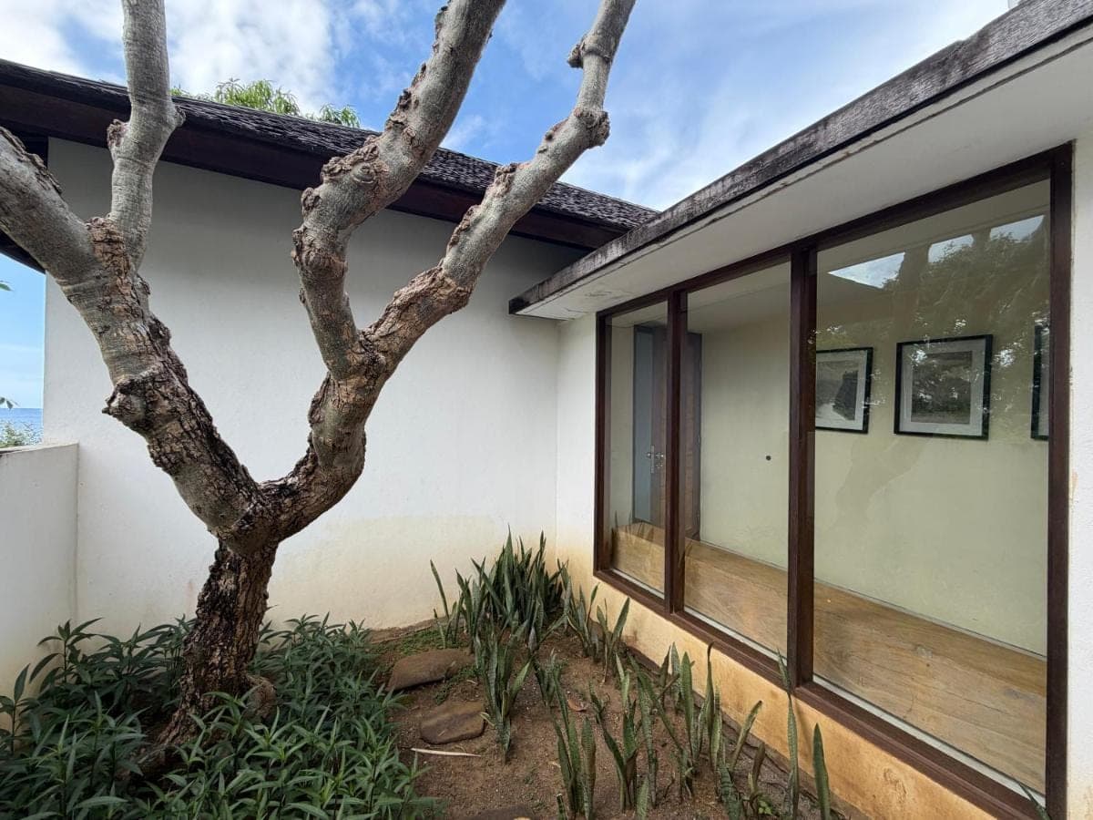 a house with a tree in front of it at Villa Bukit Segara in Amed