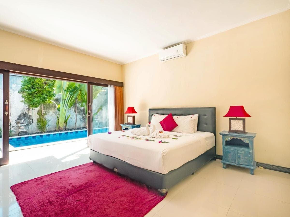a bedroom with a bed and a large window at Terrace Bali Villa in Nusa Dua