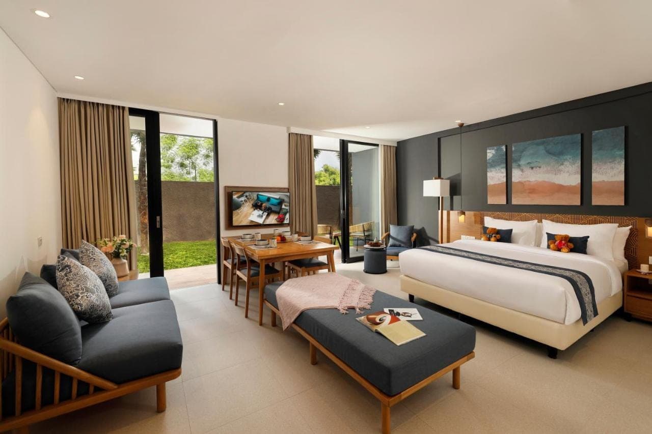 a hotel room with a bed and a living room at Citadines Berawa Beach Bali Resort in Canggu