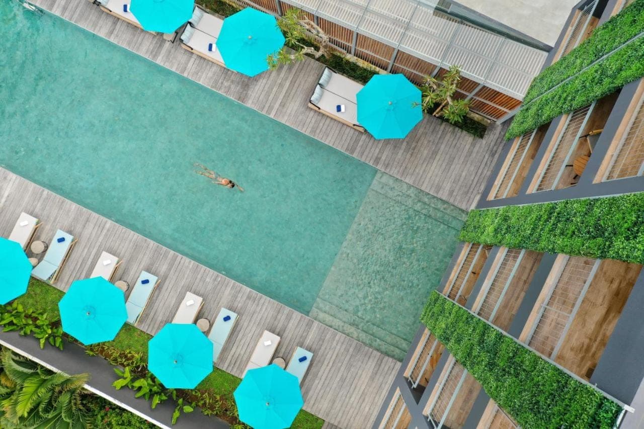 an overhead view of a pool with a person swimming in it at Citadines Berawa Beach Bali Resort in Canggu