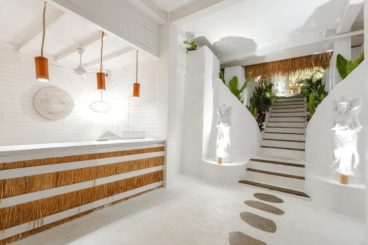 a bathroom with white walls and a staircase with white floors at Gravity Boutique Suites in Uluwatu