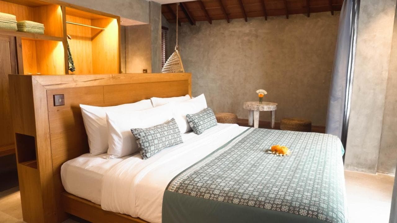 a bedroom with a large white bed with pillows at Annora Villas Seminyak in Seminyak