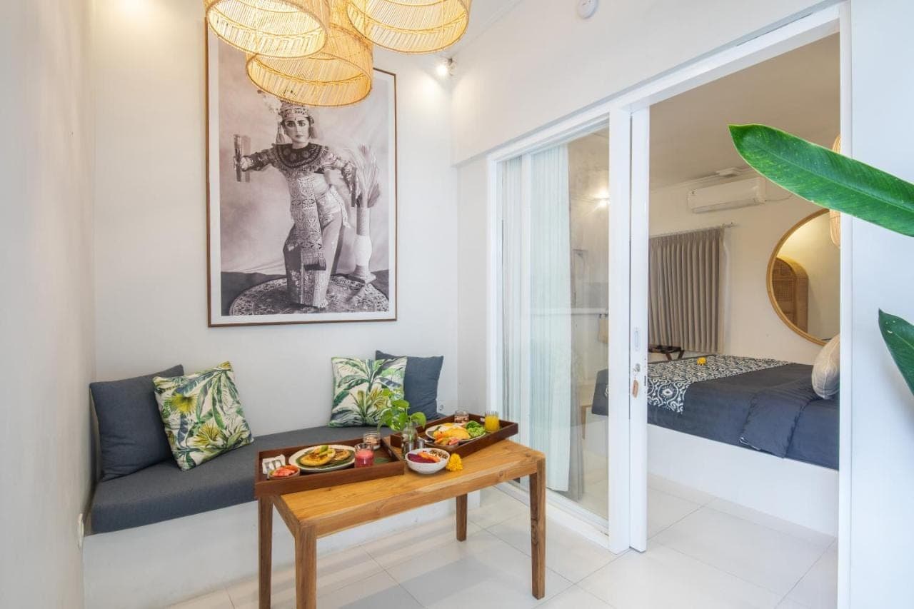 a living room with a table and a bed at The Hepburn Seminyak ADULTS ONLY Chic Boutique Room with Pool 900m Walk to Beach in Seminyak