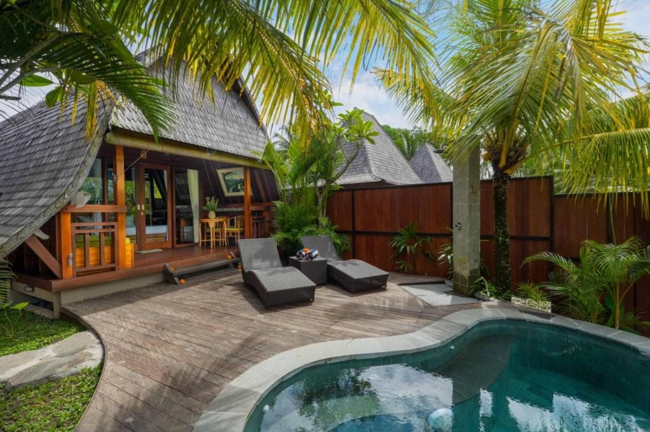 a backyard with a swimming pool and a house at PB Pondok Gandalangu Suite Villas Ubud Bali in Ubud