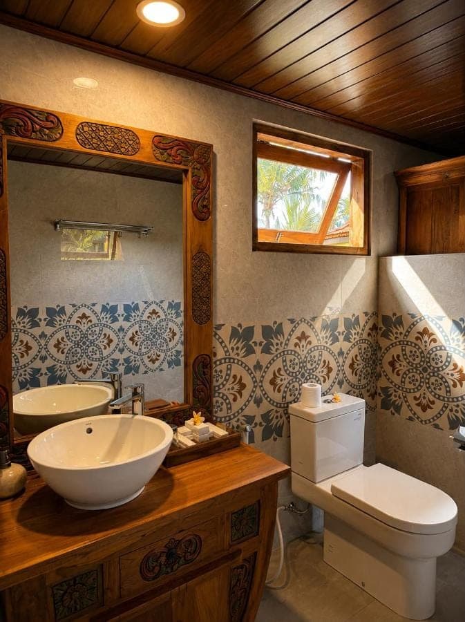 a bathroom with a sink and a toilet and a mirror at Alamdhari Villa Sidemen in Sidemen