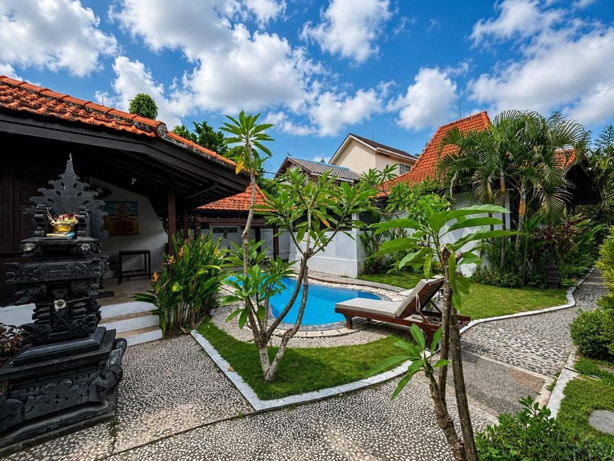 a backyard with a pool and a house at Surfer Paradise Villas Bali in Canggu
