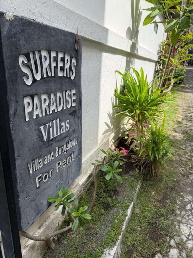 a sign that reads writers paradise villas with plants at Surfer Paradise Villas Bali in Canggu