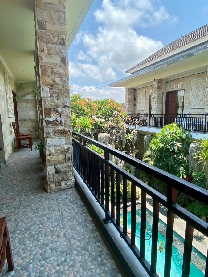 a balcony of a house with a swimming pool at Frog Homestay Sanur in Sanur