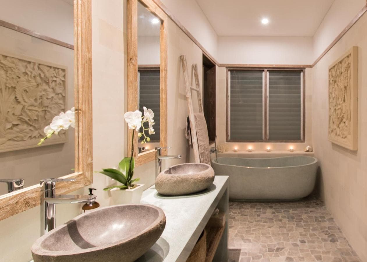 a bathroom with a large tub and a sink and a bath tub at Aloha Beach House Bingin Villas in Uluwatu
