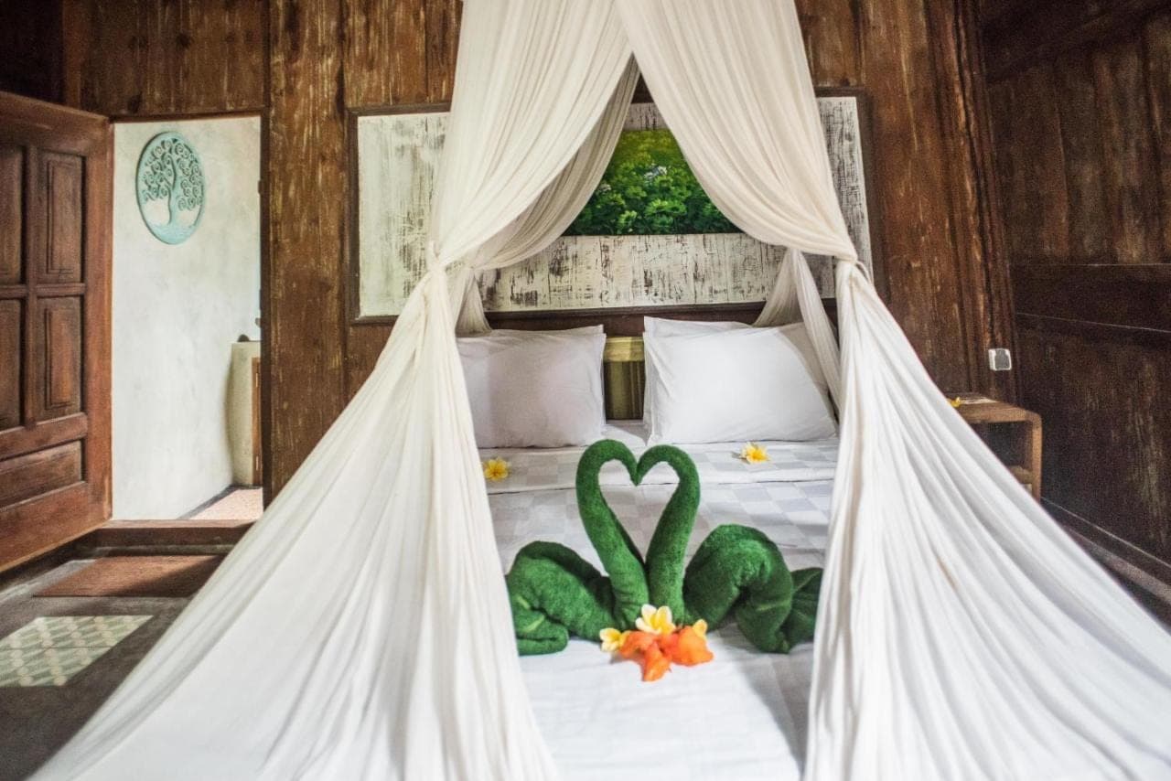 a bedroom with a bed with a bed mosquito net at Arana Garden Ubud in Ubud