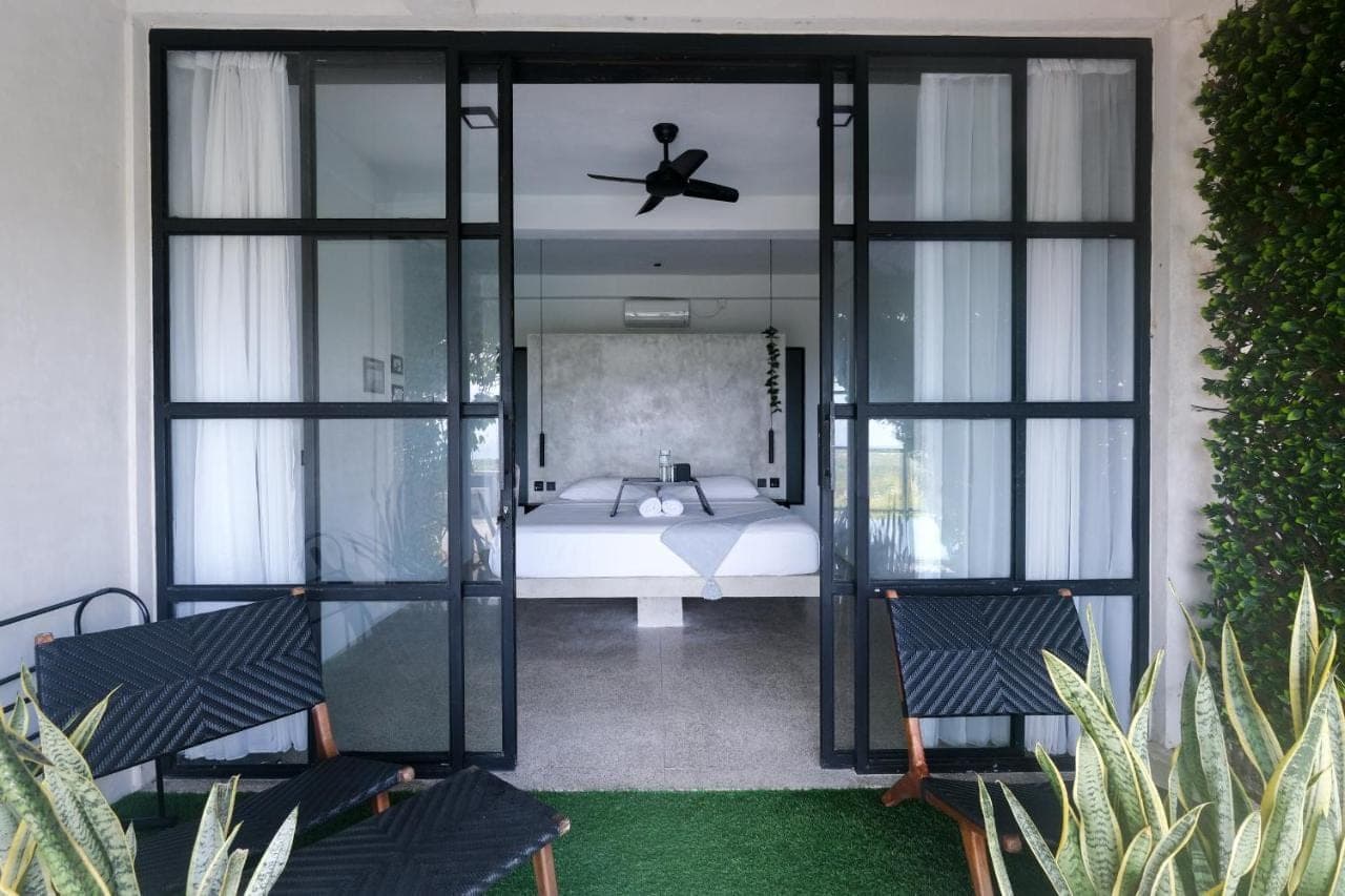 a bedroom with a bed and a ceiling fan at OCEANNA - Uluwatu, Bali in Uluwatu