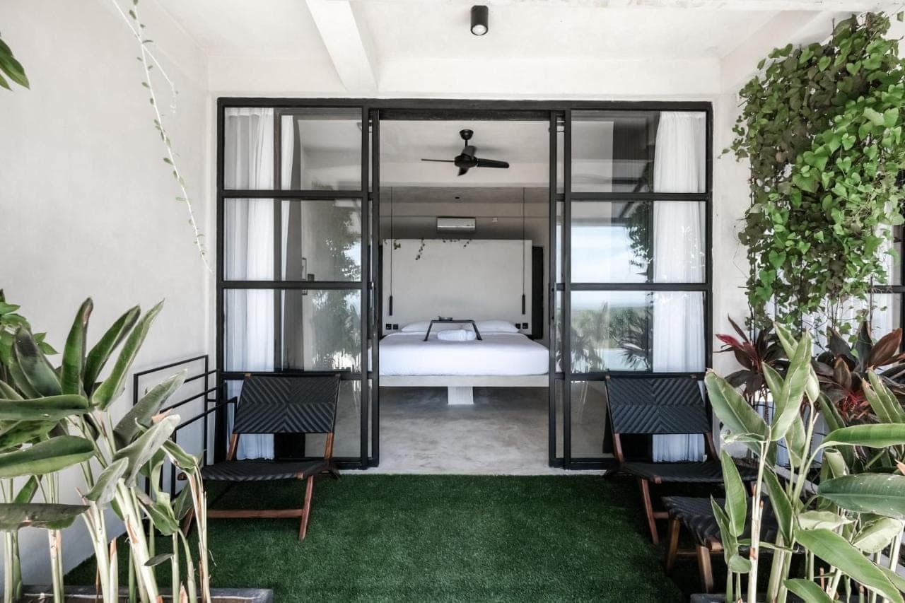 a bedroom with a bed and some plants at OCEANNA - Uluwatu, Bali in Uluwatu