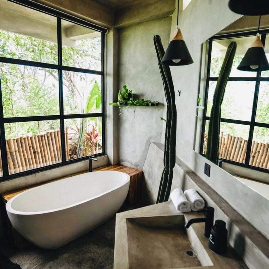 a bathroom with a large white tub and windows at OCEANNA - Uluwatu, Bali in Uluwatu