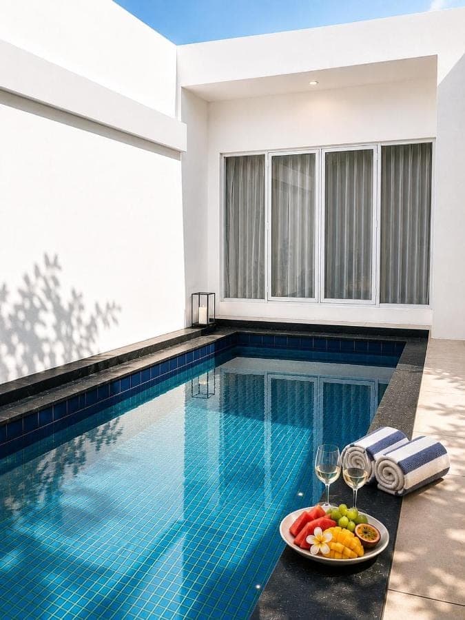a pool with a plate of fruit and wine glasses at Nusa Dua Oasis Elara 2BR Private Pool Villa in Nusa Dua
