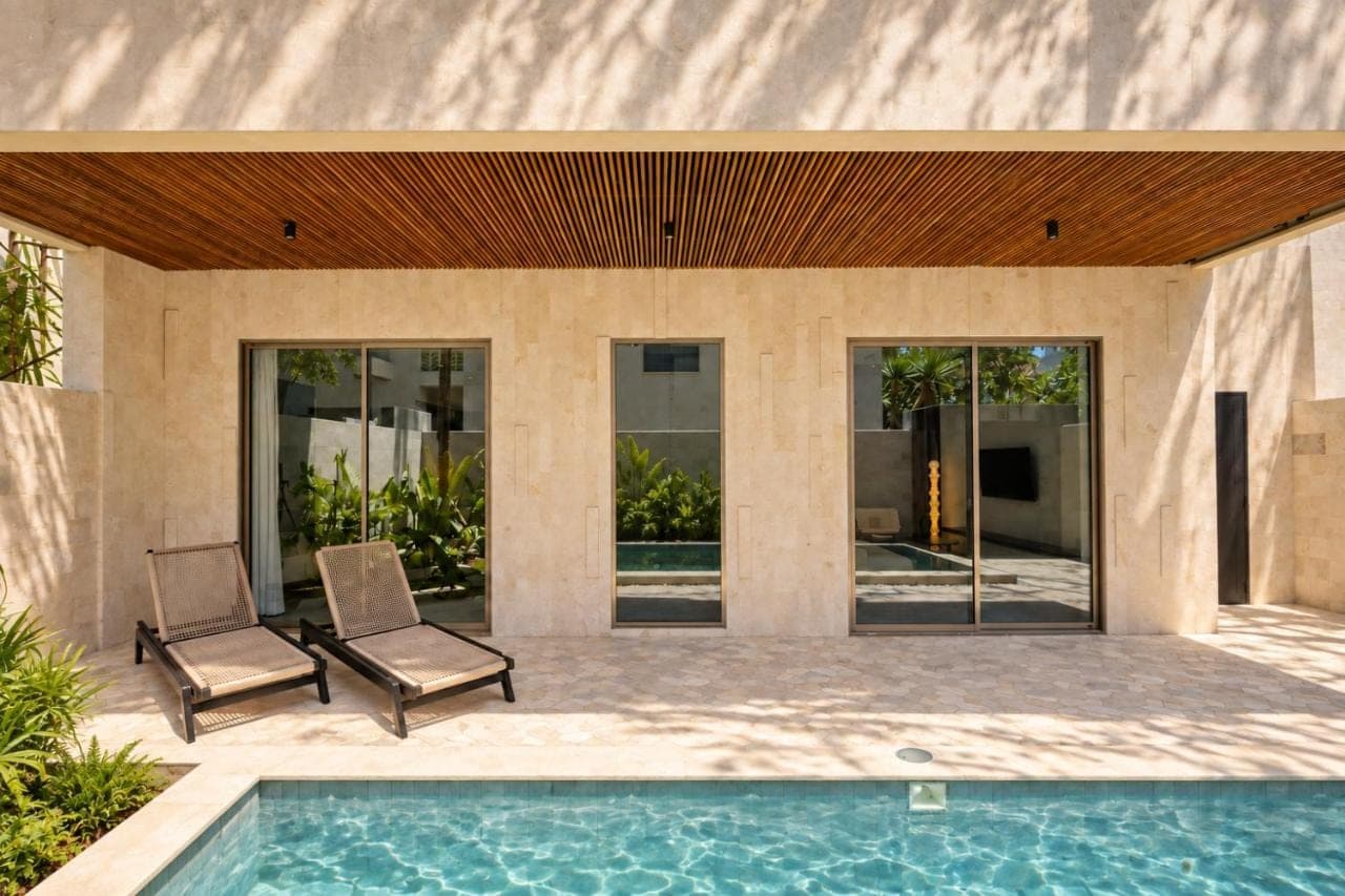 a patio with two chairs and a swimming pool at Surfside Uluwatu Resort in Uluwatu