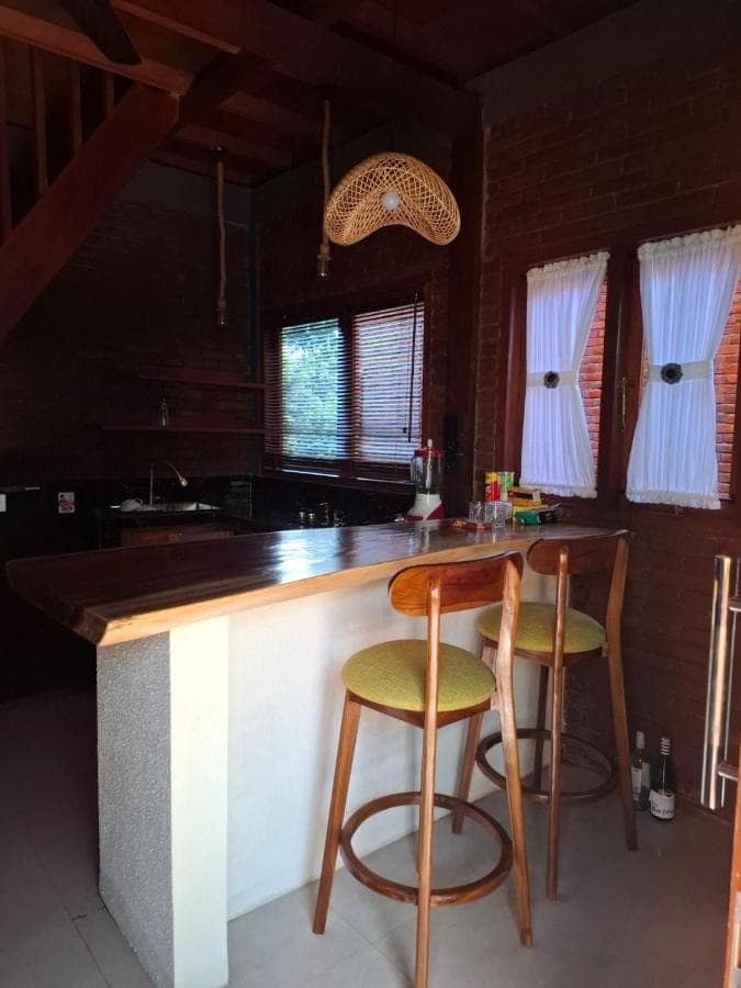 a kitchen with a counter and two stools at Pondok Kembar Homestay in Uluwatu