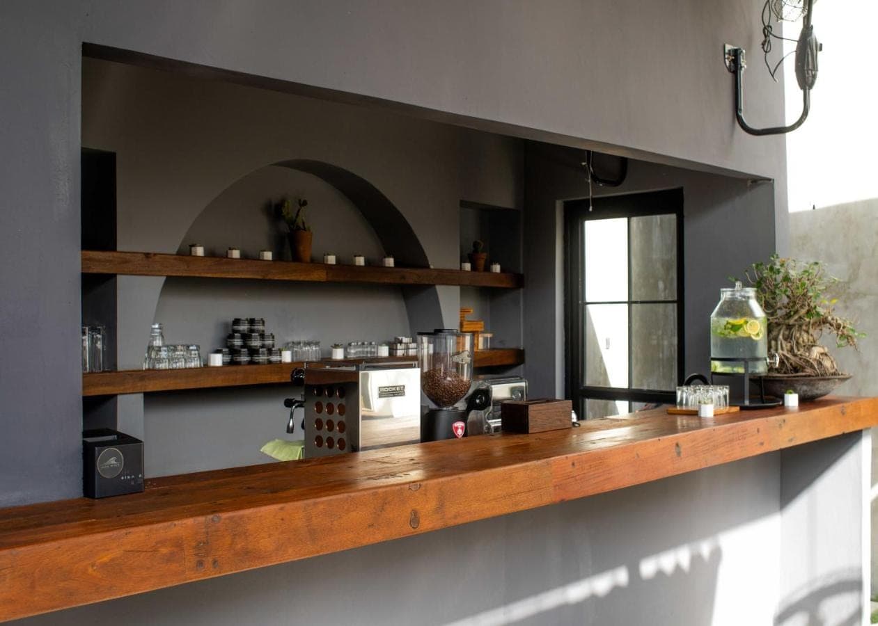 a kitchen with a wooden counter top in a room at Iron Wave Uluwatu in Uluwatu