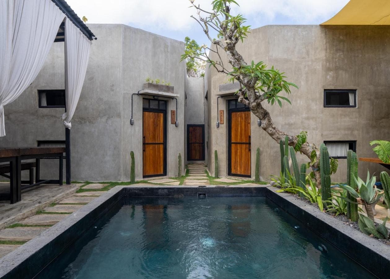 a house with a swimming pool in front of it at Iron Wave Uluwatu in Uluwatu