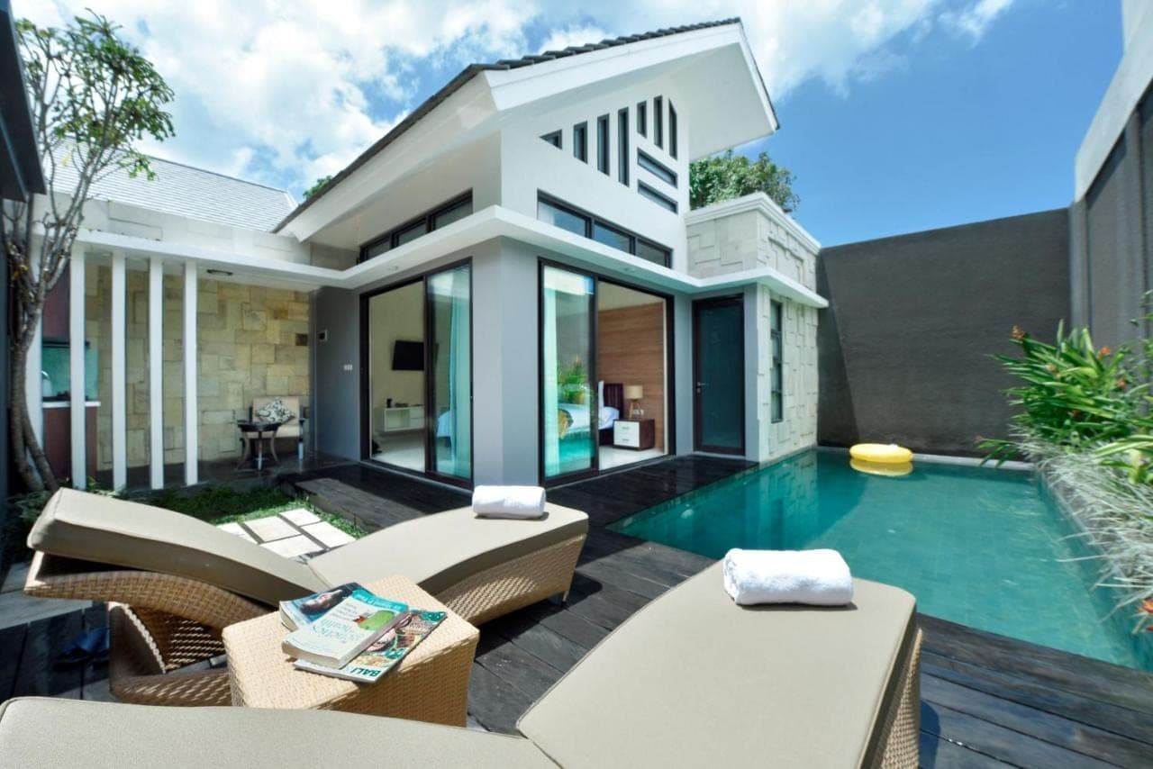 a house with a swimming pool in the backyard at La Paradis Villa in Canggu