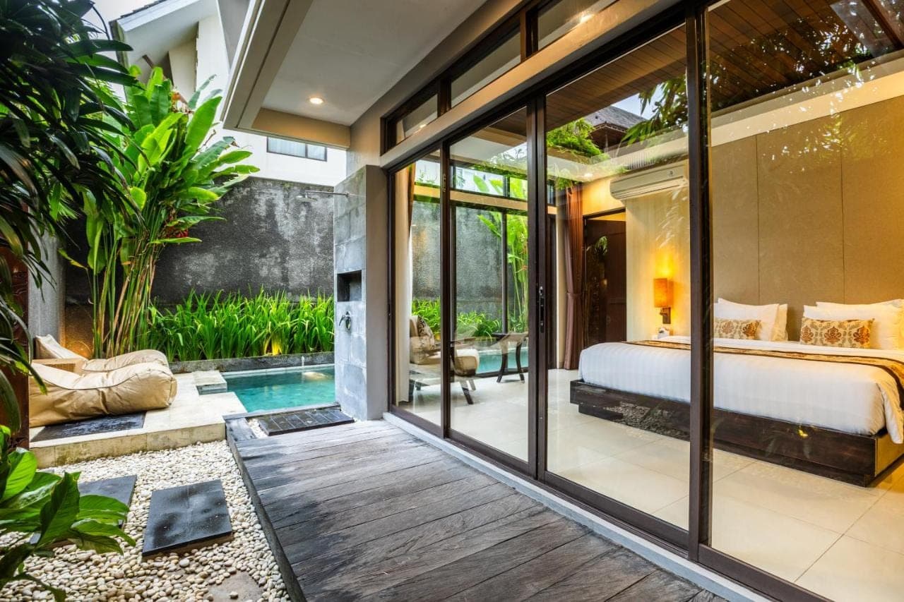 a bedroom in a villa with a bed and a pool at La Paradis Villa in Canggu
