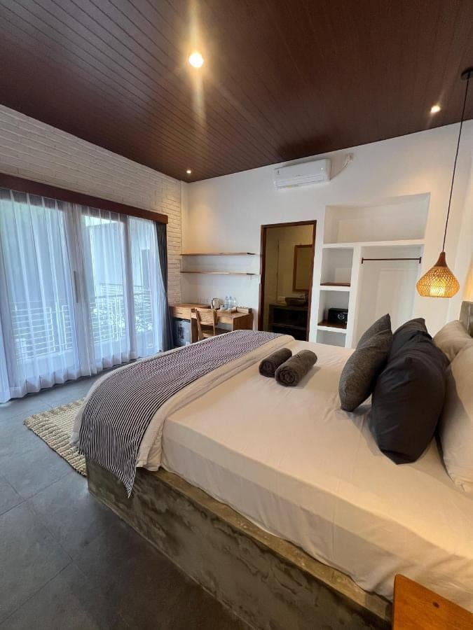 a bedroom with a large bed with pillows on it at Ishana House Padang-Padang in Uluwatu
