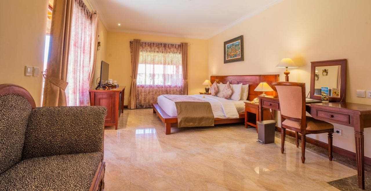 a hotel room with a bed and a desk at The Grand Bali Nusa Dua in Nusa Dua