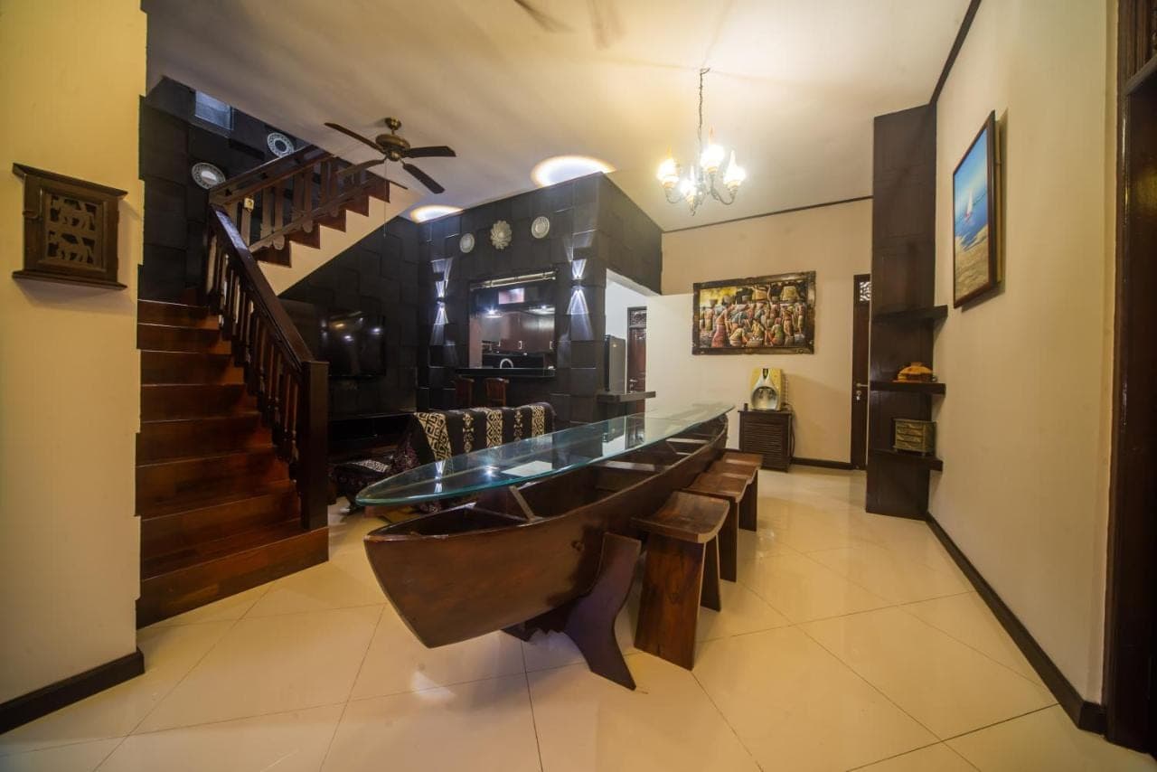 a dining room with a bench and a stair case at 3Bedroom Private Pool Tatiya Villa - Nusa Dua in Nusa Dua