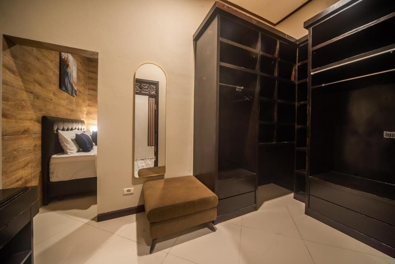 a dressing room with a bed and a mirror at 3Bedroom Private Pool Tatiya Villa - Nusa Dua in Nusa Dua