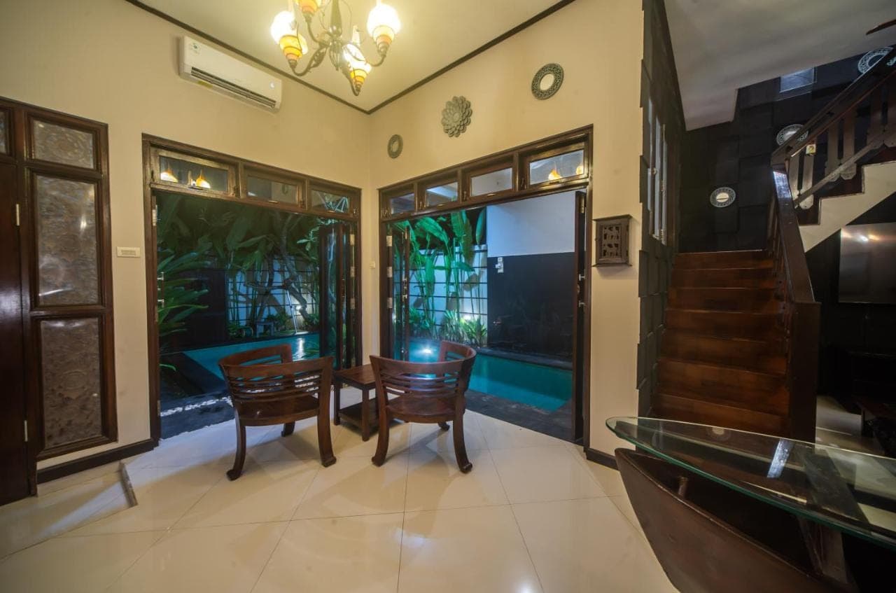 a dining room with a table and chairs and a window at 3Bedroom Private Pool Tatiya Villa - Nusa Dua in Nusa Dua