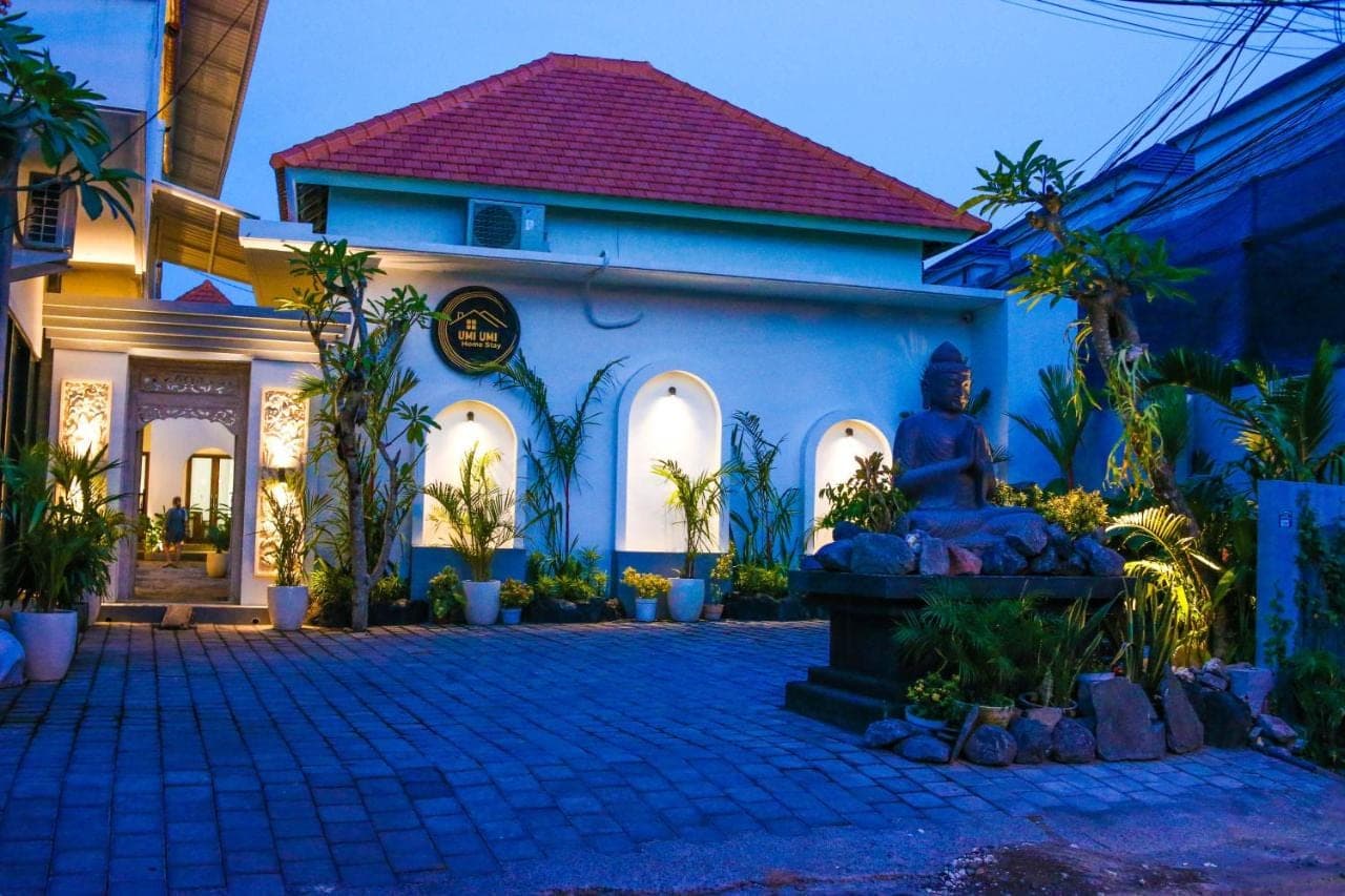 a house with a statue in front of it at Umi Umi Homestay Sanur in Sanur