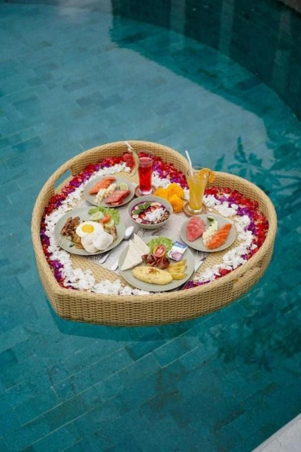 a tray of food on a table in a swimming pool at Villa Palma Blanca Canggu by Nagisa Bali in Canggu