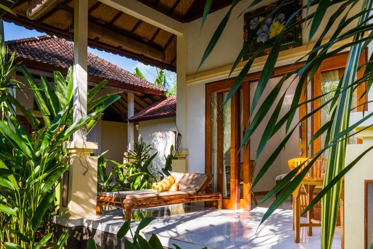 a porch of a house with a bench and plants at Oasis in Amed