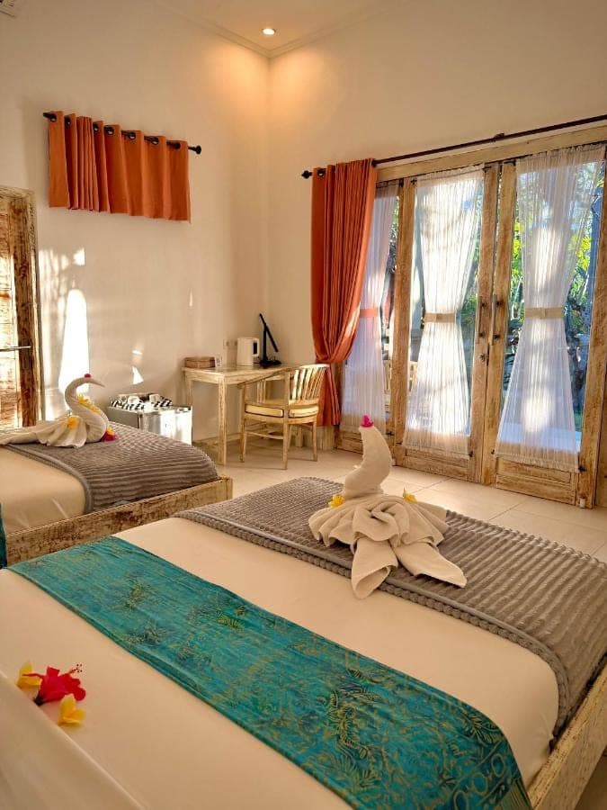 a bedroom with two beds with towels on them at Oasis in Amed
