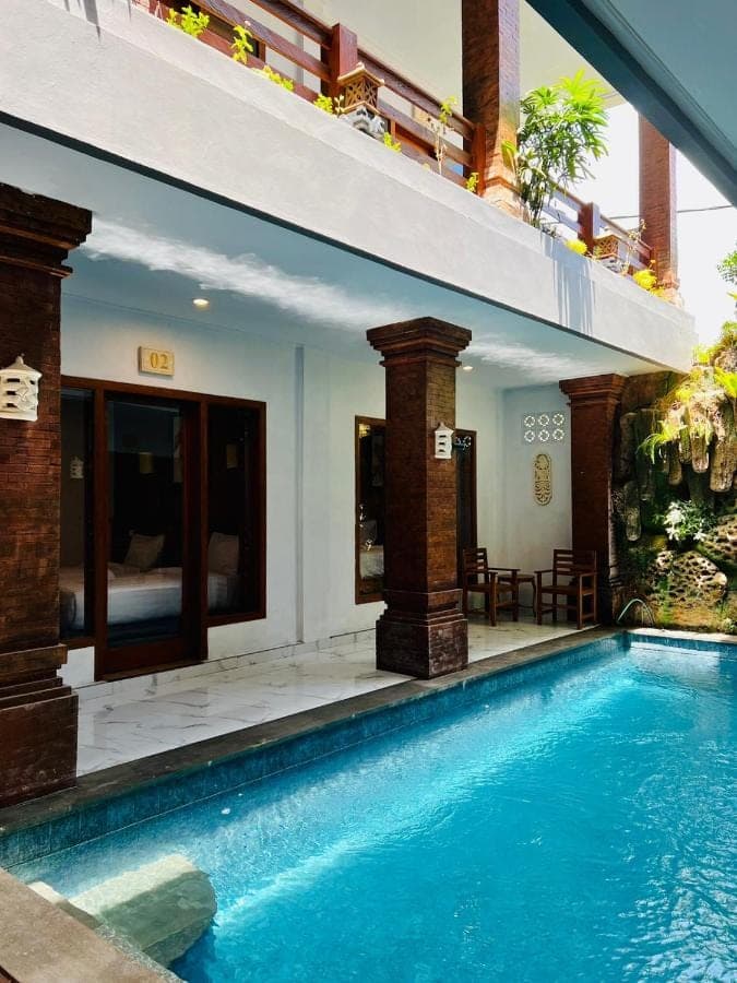 a swimming pool in front of a villa at Milky Way Homestay Canggu in Canggu