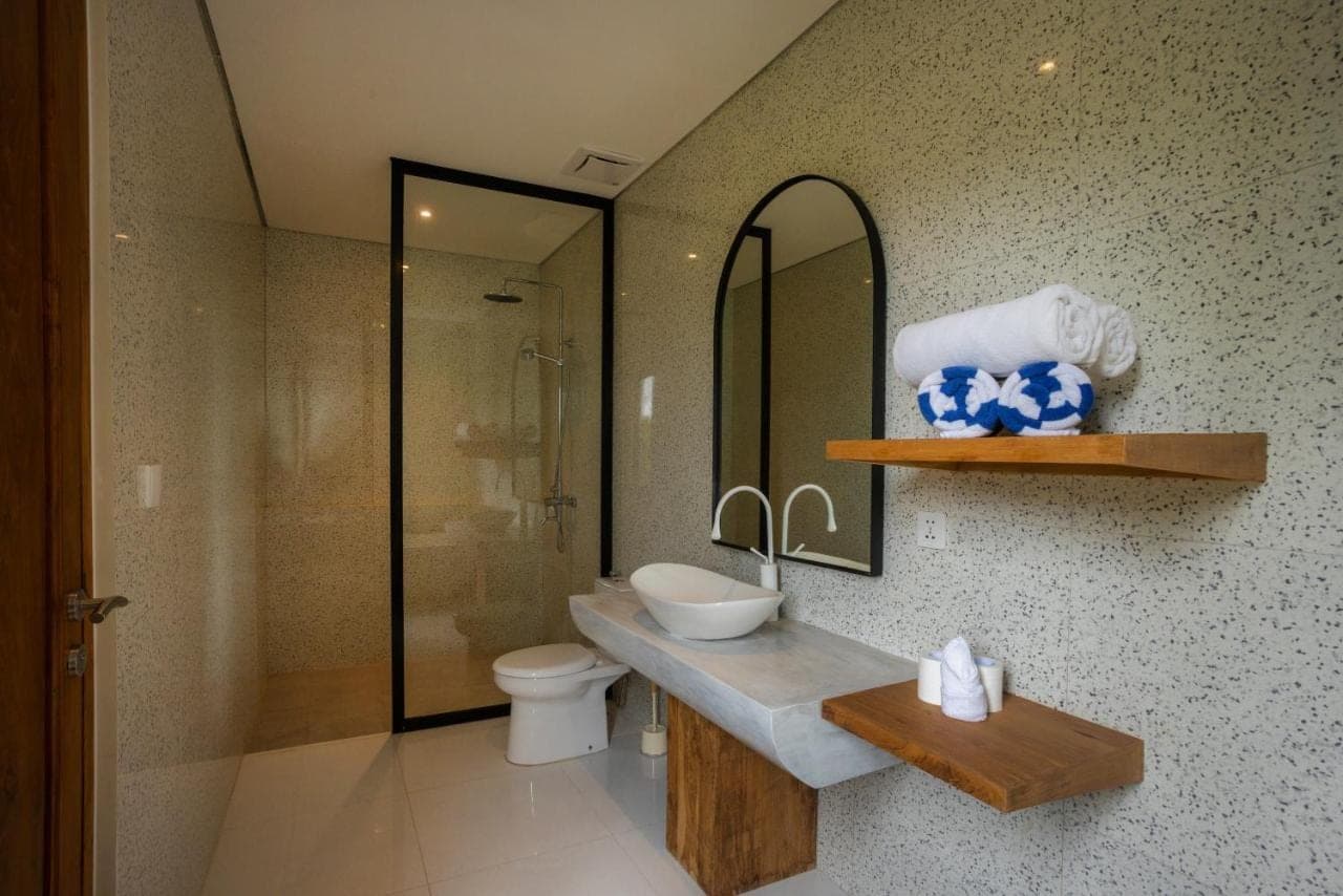 a bathroom with a sink and a toilet and a mirror at Villa Batu Putih 2 Seminyak - BEHIND LA FAVELA in Seminyak