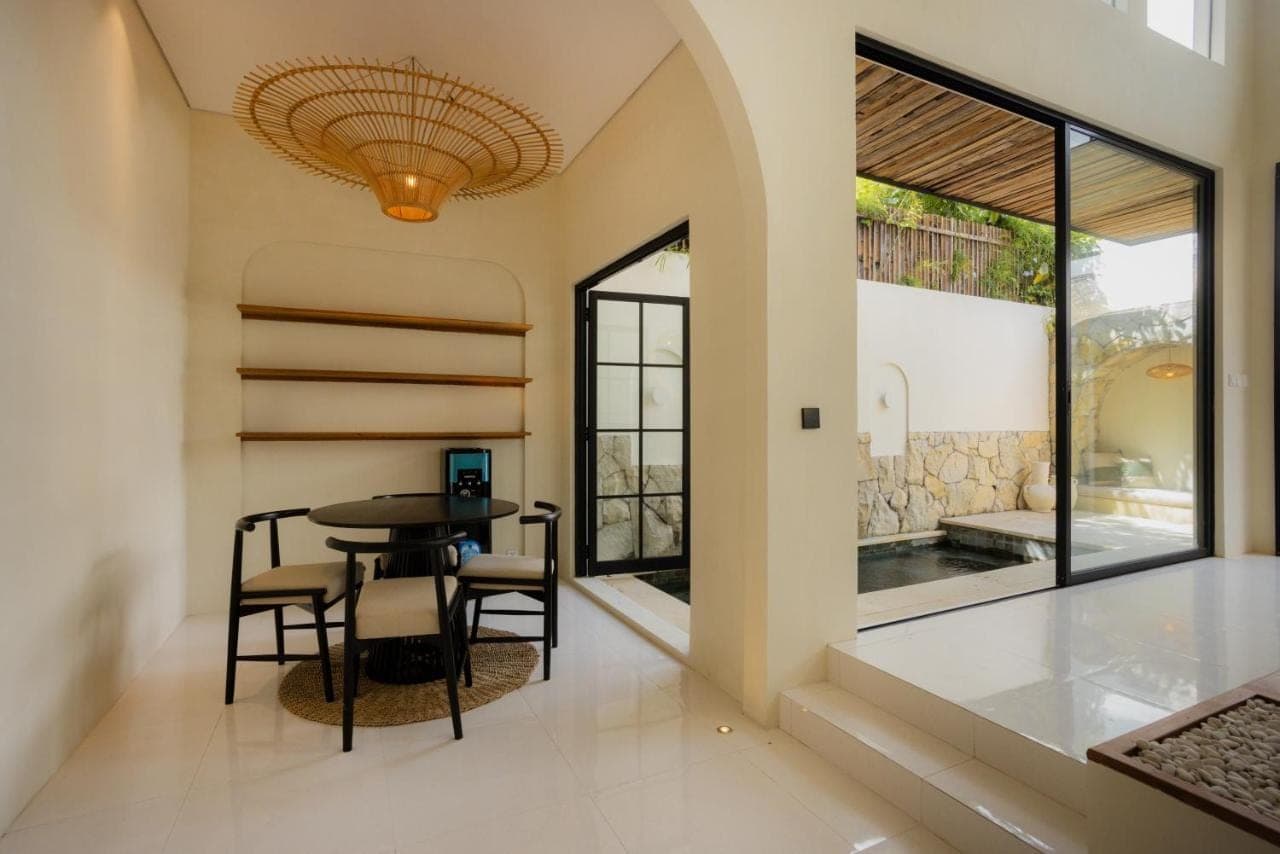 a dining room with a table and chairs and a window at Villa Batu Putih 2 Seminyak - BEHIND LA FAVELA in Seminyak