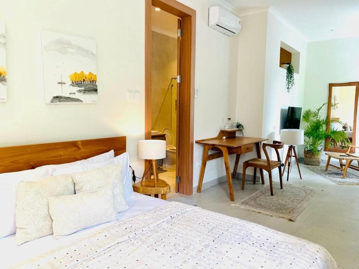 a bedroom with a bed and a table and a desk at Unite Villa Balangan in Uluwatu