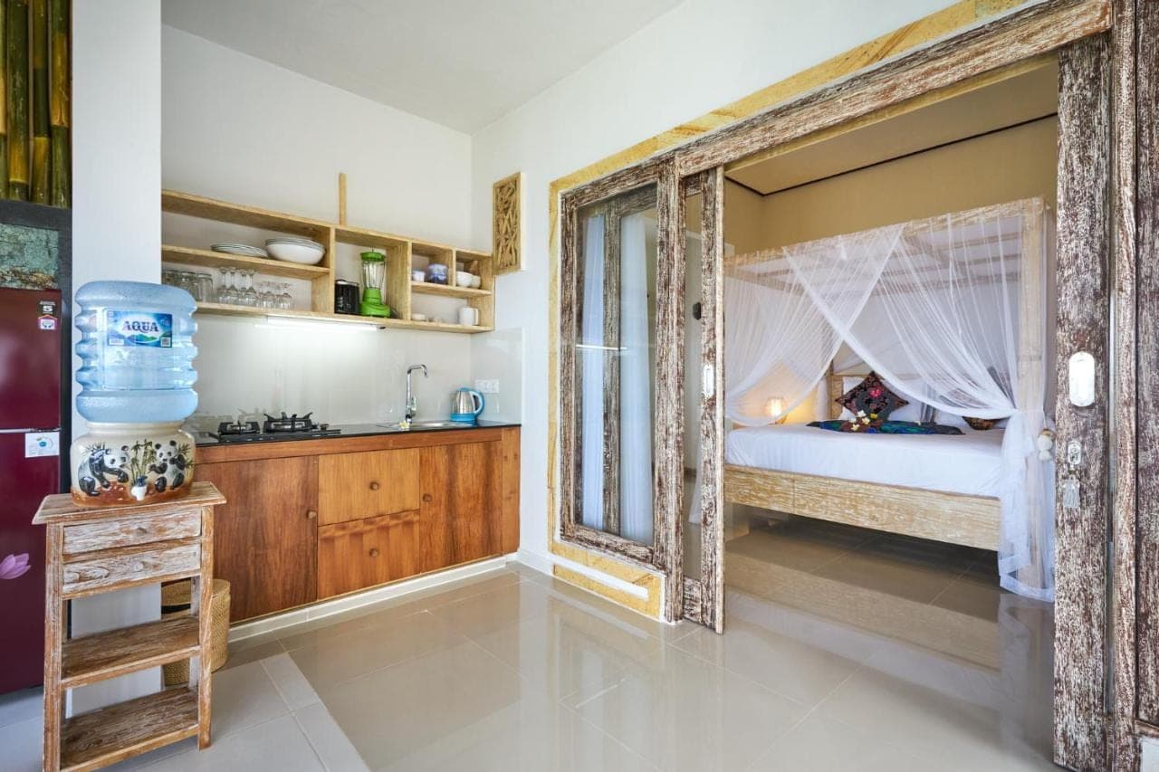 a bedroom with a bed with a large window at Arungan Villas in Amed