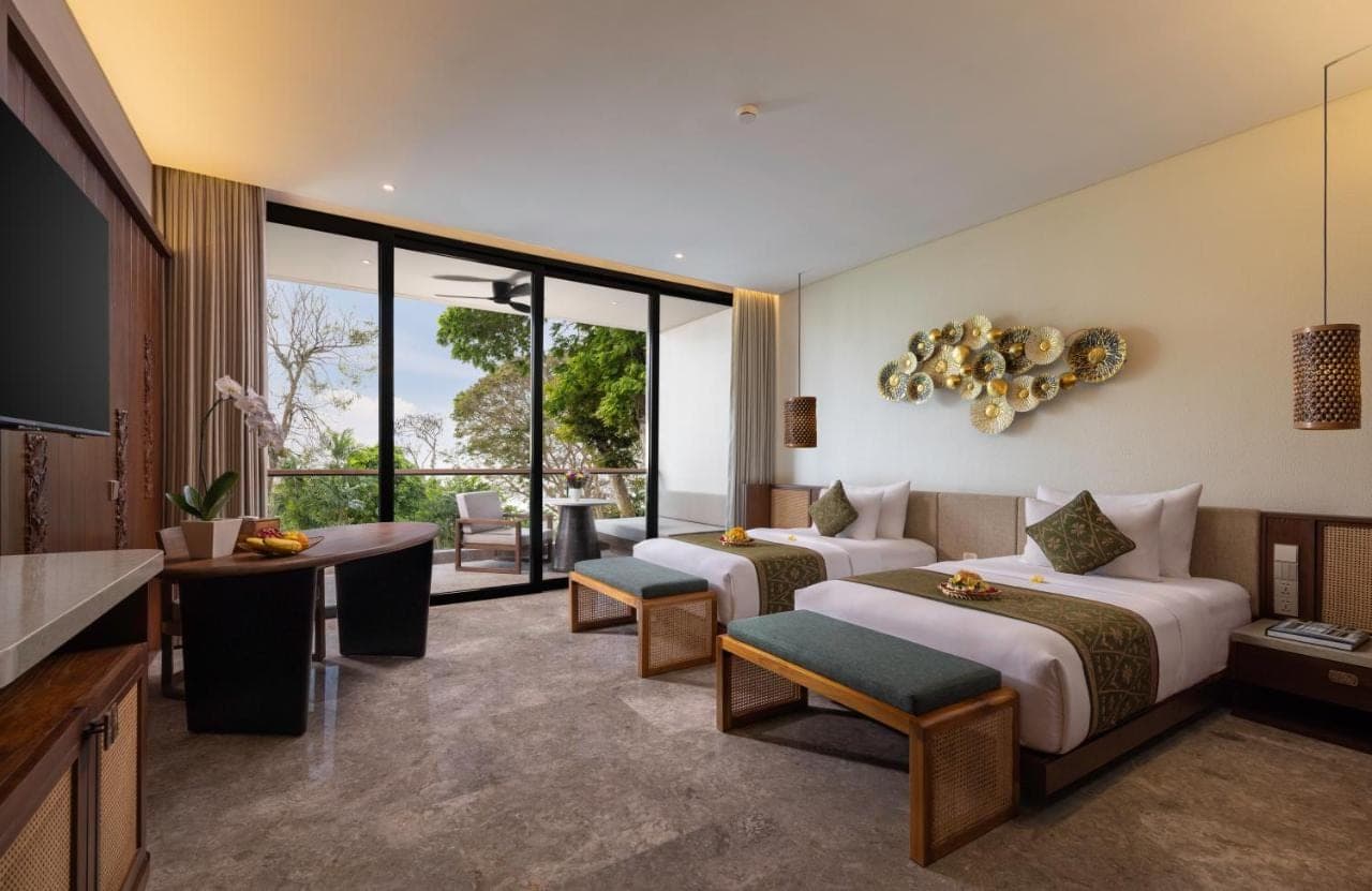 a hotel room with two beds and a living room at Sumitra Luxury Villas & Resort by Pramana in Sanur