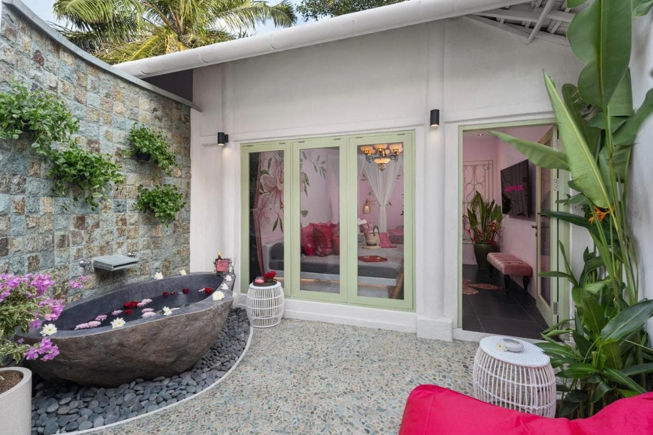 a bath tub sitting outside of a house at PinkCoco Uluwatu - Constant Surprises & for Cool Adults Only in Uluwatu