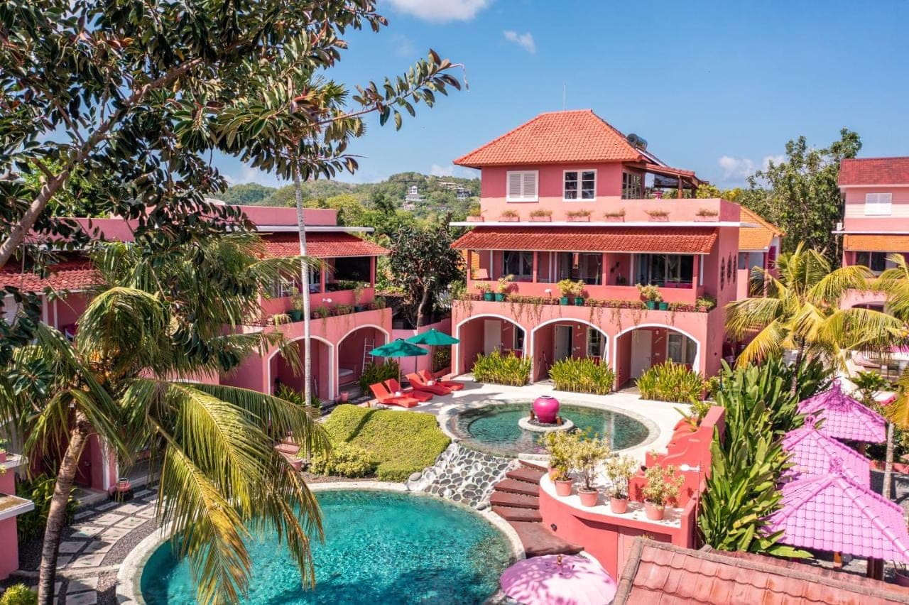 an aerial view of a pink building with a swimming pool at PinkCoco Uluwatu - Constant Surprises & for Cool Adults Only in Uluwatu