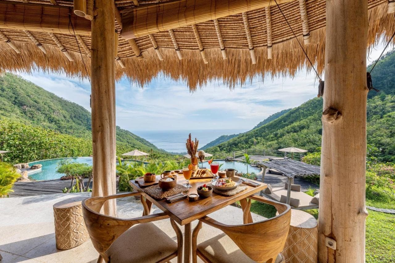 a table and chairs on a patio with a view at MATHIS Lodge Amed in Amed