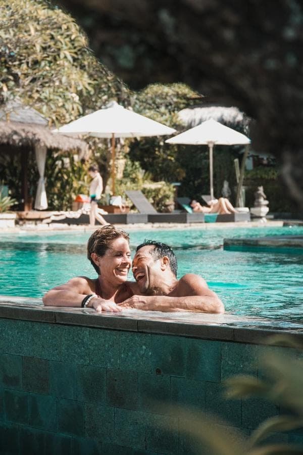 a man and a woman in a swimming pool at Uluwatu Cottages in Uluwatu