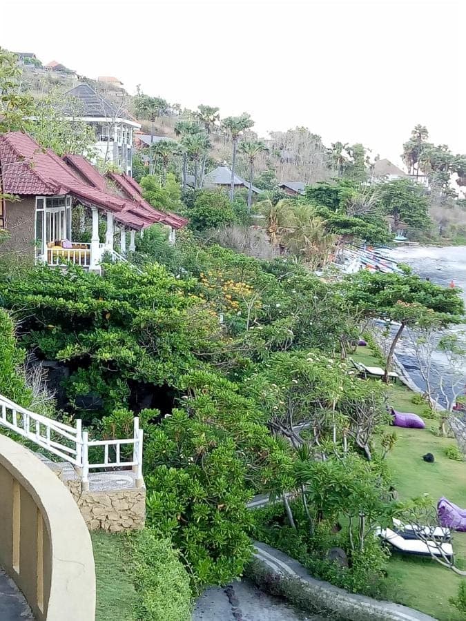 a view of a yard with a house and the water at Stairway To Heaven Bungalows and Restaurant in Amed