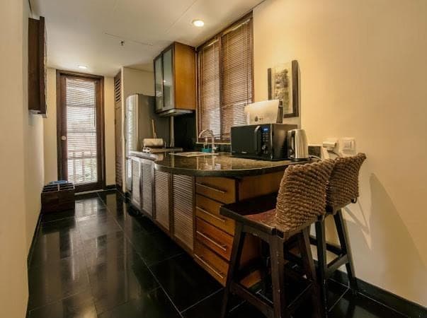 a kitchen with a counter with a sink and a chair at Ruby Nusa Dua Bali in Nusa Dua